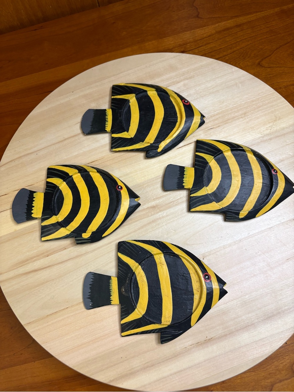 Four coasters that are  hand-painted and made of wood.
